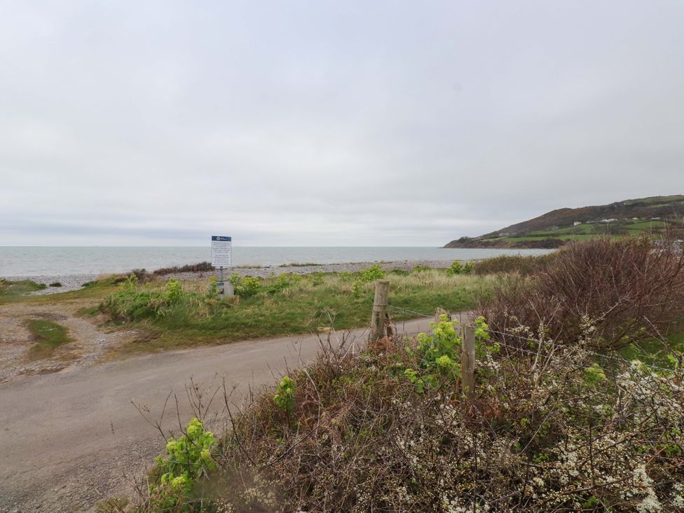 A view of the sea and a gravel road at Belan Wen in Llanddona near Pentraeth