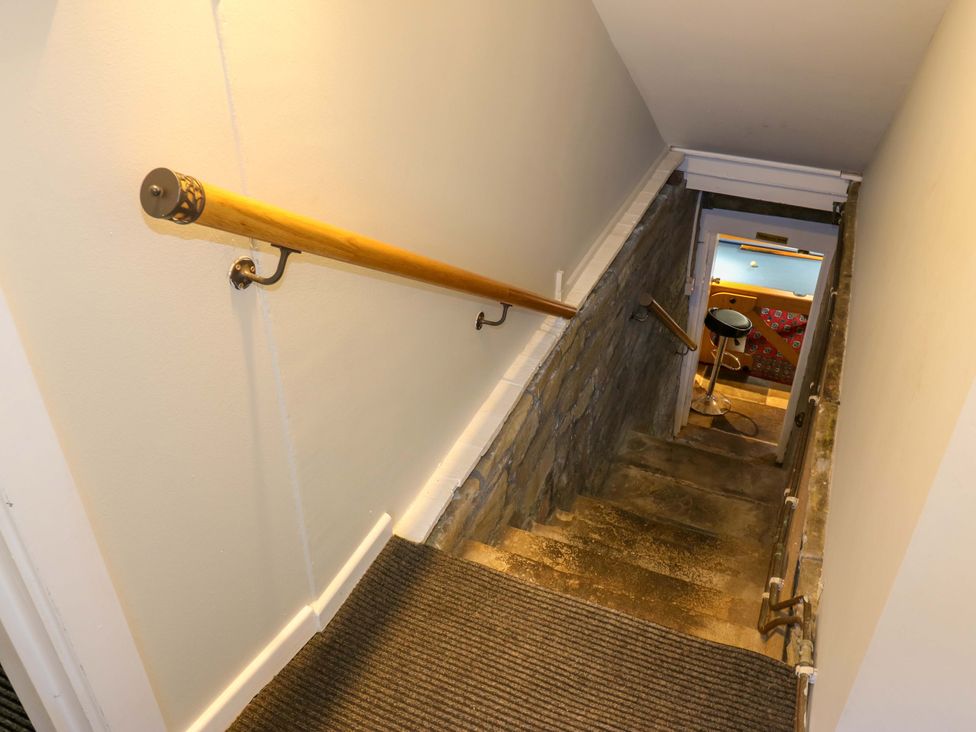 A staircase with stone wall and handrail at The Old Post Office - Pet Friendly Group Stays in Holmfirth