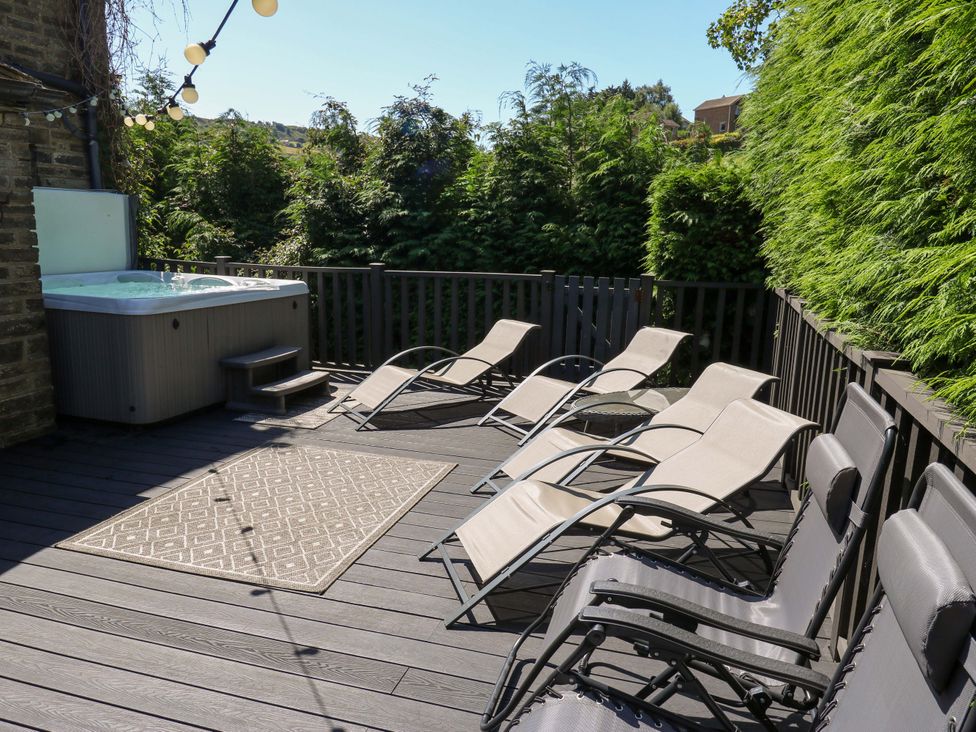 An outdoor area with a hot tub and sun loungers at The Old Post Office - Pet Friendly Group Stays in Holmfirth
