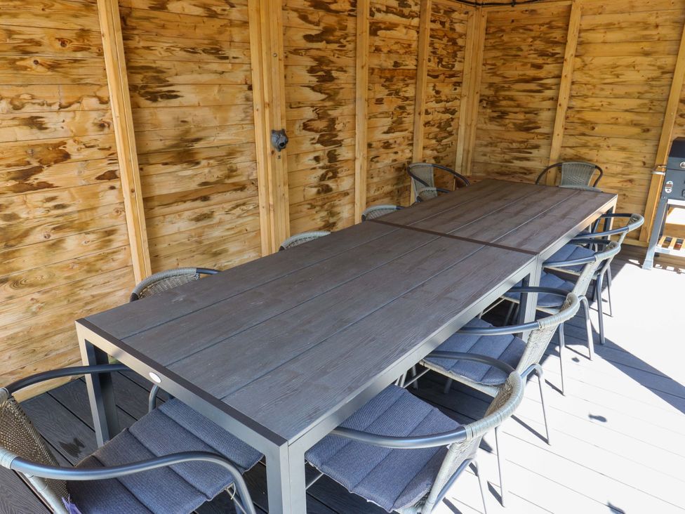 An outdoor dining area with a long table and chairs at The Old Post Office - Pet Friendly Group Stays in Holmfirth