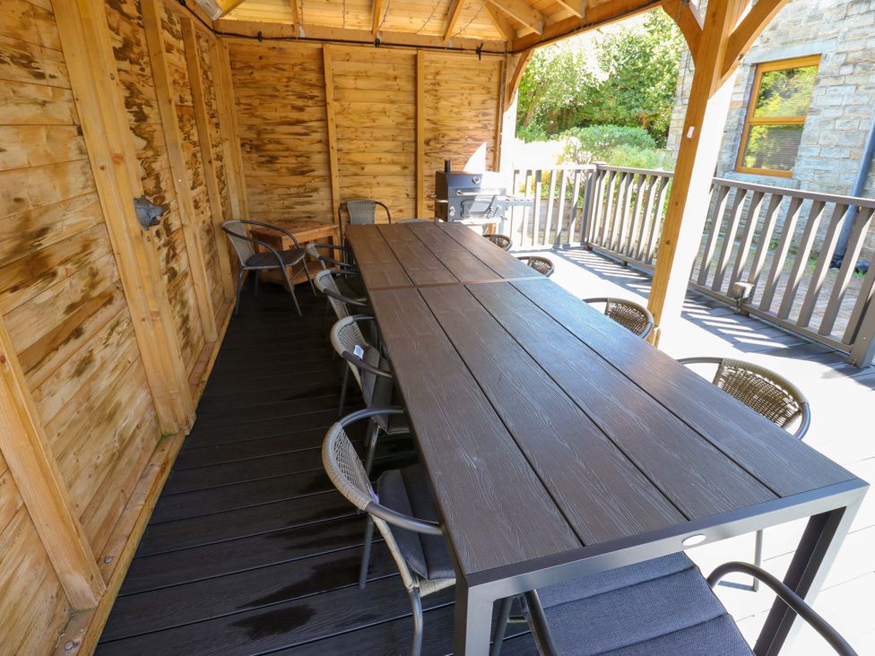 An outdoor dining area with a large table and chairs at The Old Post Office - Pet Friendly Group Stays in Holmfirth