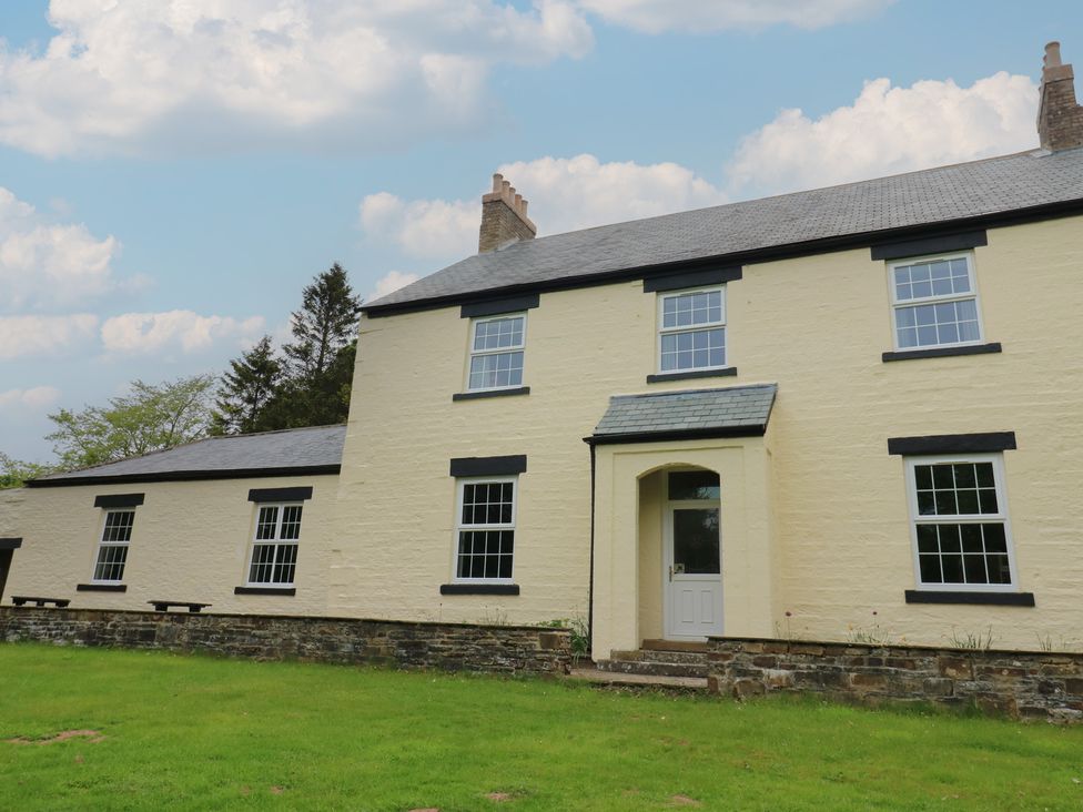 A beige house with multiple windows a front door and a green lawn at Nenthead House in Nenthead near Alston