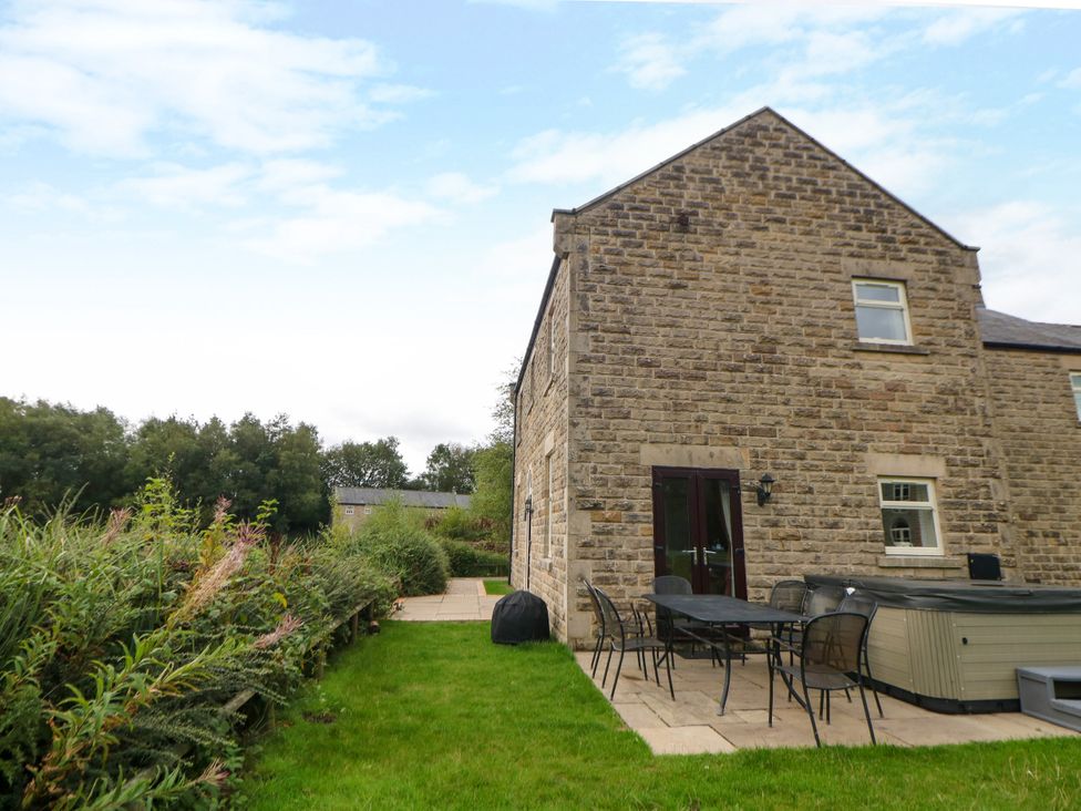 An outdoor area with a stone wall and patio furniture at Hardwick, Darley Moor near Two Dales