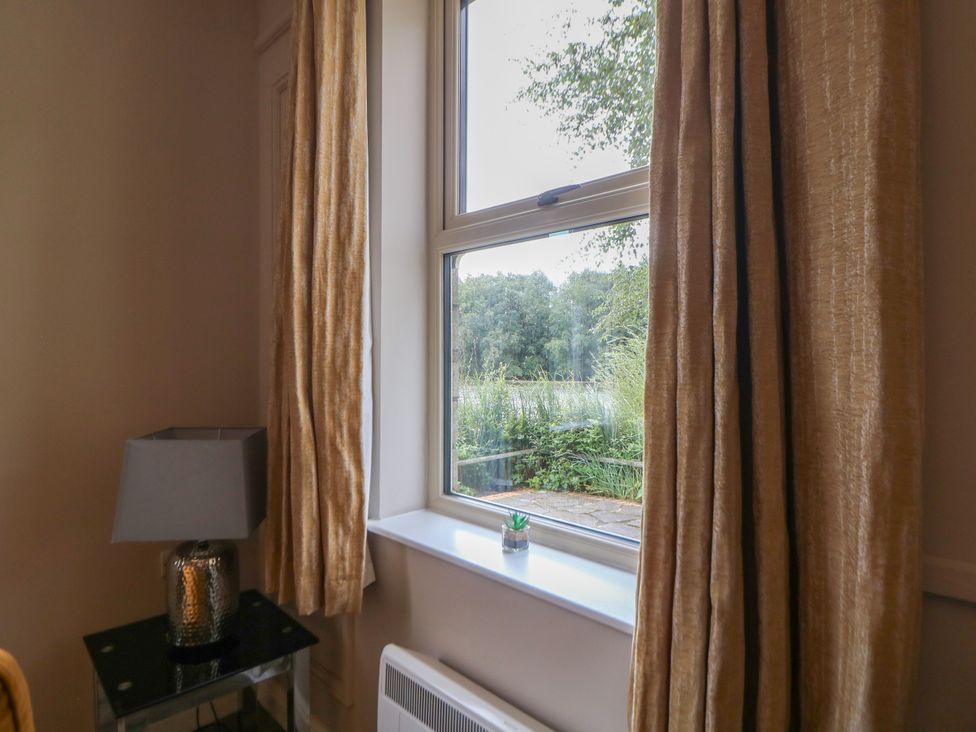 A living room with a window and a lamp at Hardwick in Darley Moor near Two Dales
