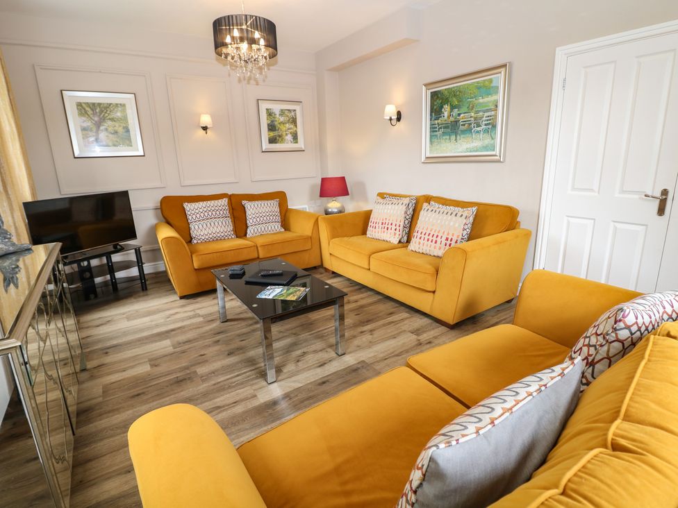 A living room with yellow sofas and a coffee table at Hardwick in Darley Moor near Two Dales
