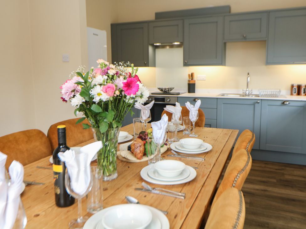 A dining room with a wooden table set for a meal at Hardwick in Darley Moor near Two Dales