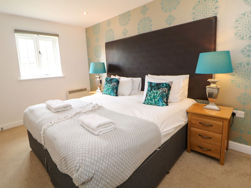 A bedroom with a double bed and bedside tables at Hartington in Darley Moor near Two Dales