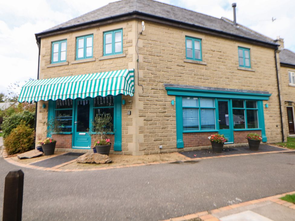 An exterior view of a stone building with green accents at Hartington in Darley Moor near Two Dales