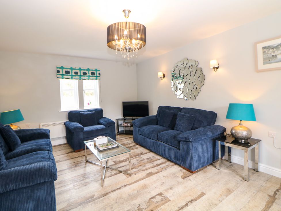 A living room with a sofa and armchair at Riber in Darley Moor near Two Dales