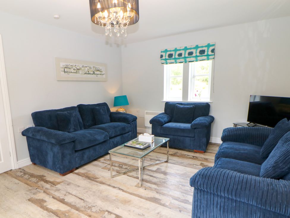 A living room with blue sofas and a coffee table at Riber in Darley Moor near Two Dales