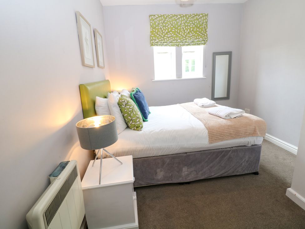 A bedroom with a bed and bedside lamp at Riber Darley Moor near Two Dales