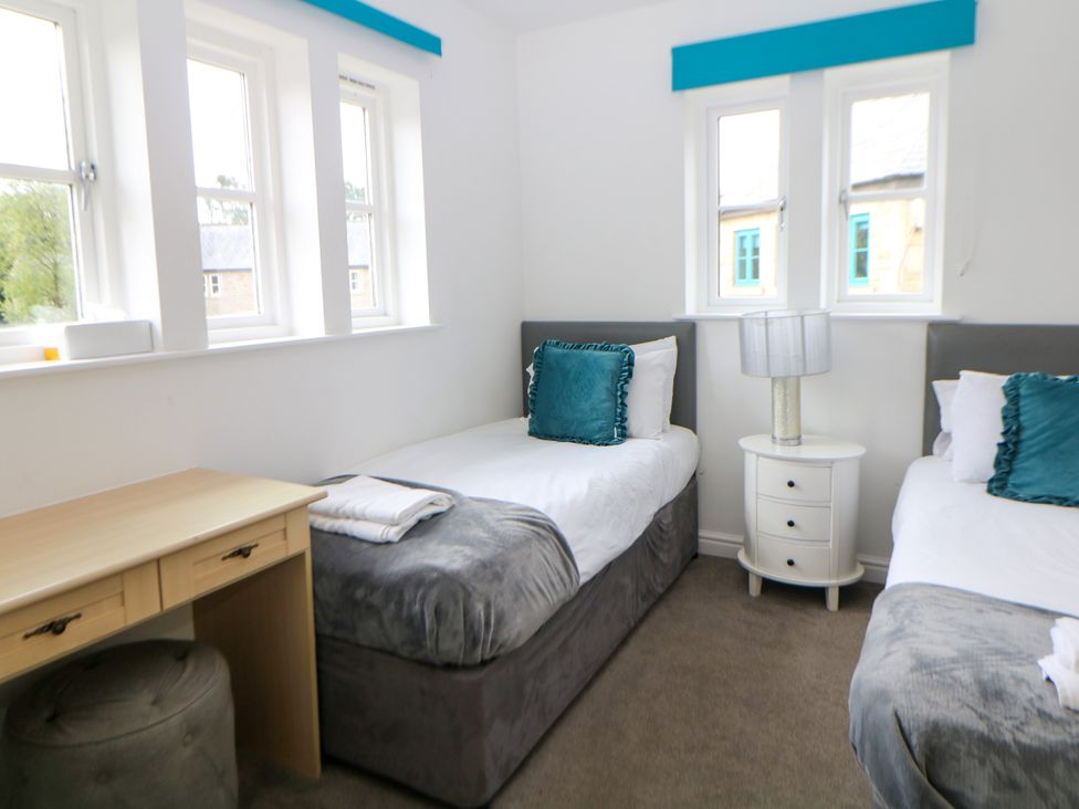 A bedroom with two beds and a desk at Riber, Darley Moor near Two Dales