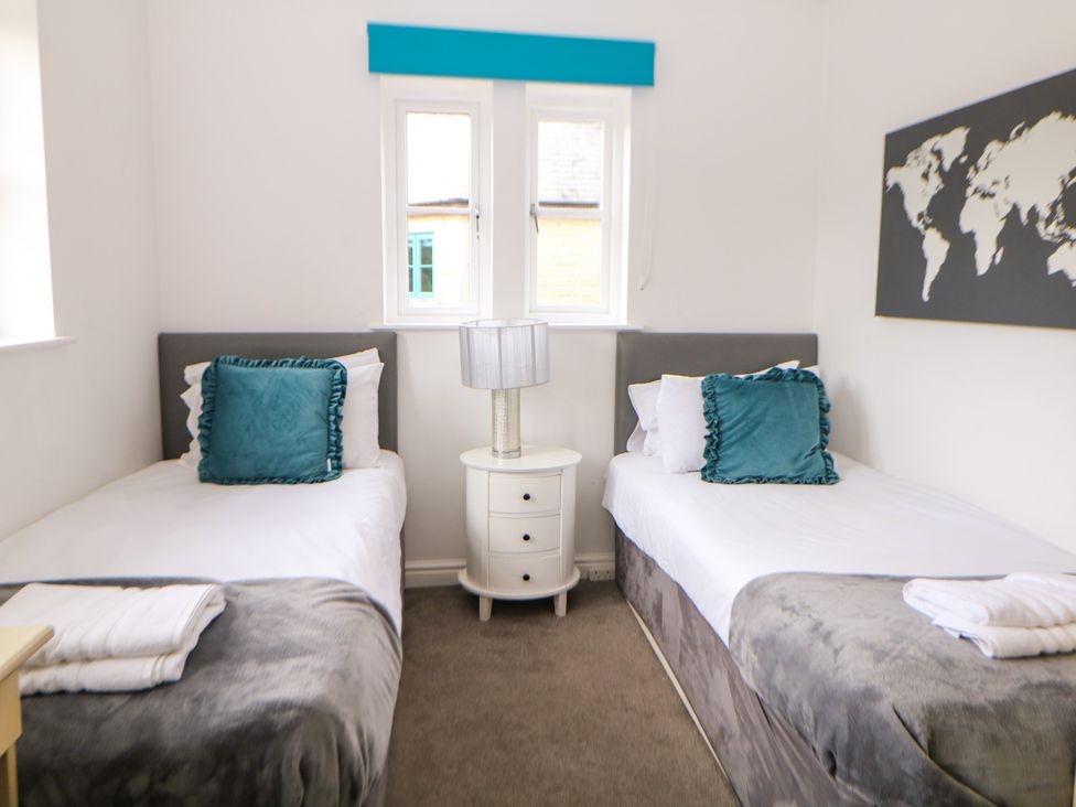 A bedroom with two single beds and a map on the wall at Riber near Darley Moor