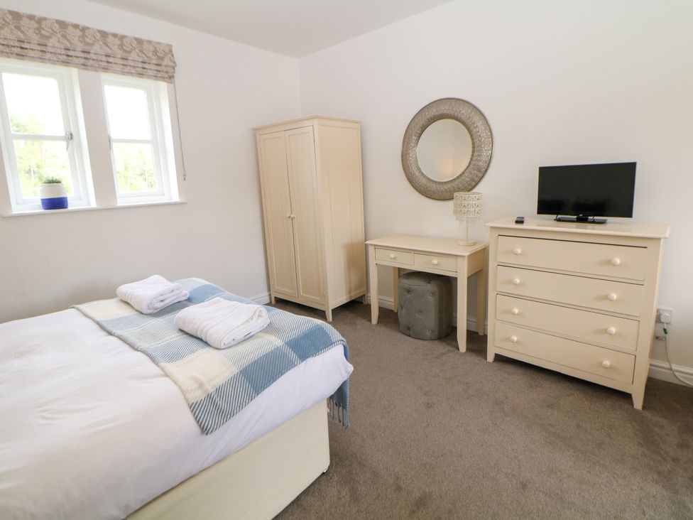 A bedroom with a bed, dresser, and TV at Riber in Darley Moor near Two Dales