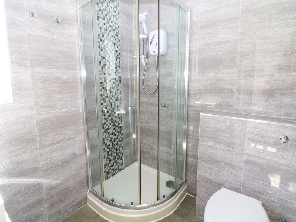 A shower and toilet in a bathroom at Riber in Darley Moor near Two Dales