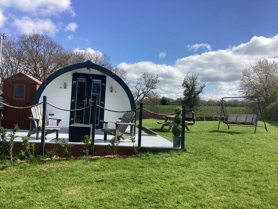 A cabin with deck chairs and a swing at Cherry Pod 2 Hookagate near Meole Brace