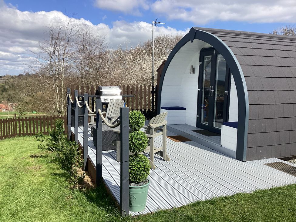 A cabin with a deck and barbecue at Cherry Pod 2 Hookagate near Meole Brace