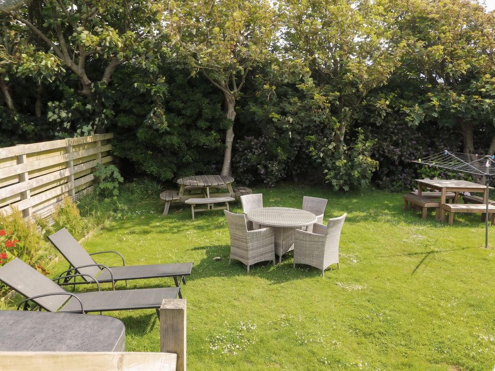 A garden with seating areas and a washing line at Porth Ewyn in Trearddur Bay