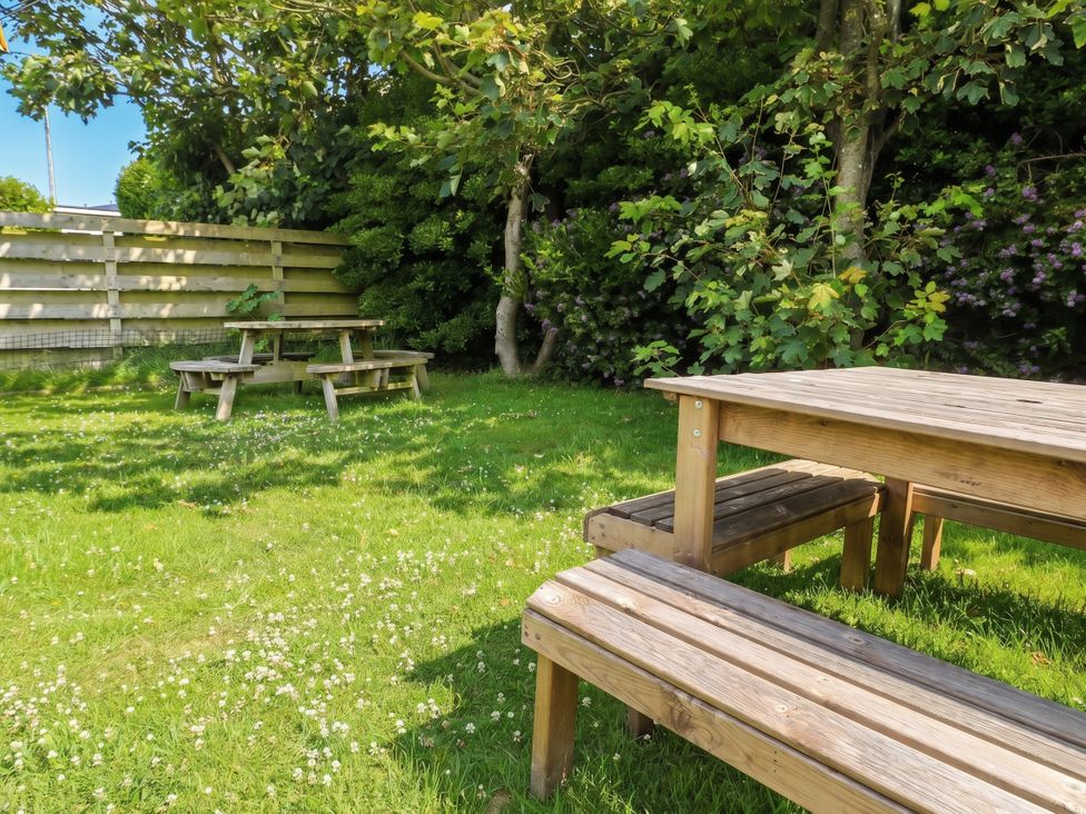A garden with tables and benches at Porth Ewyn in Trearddur Bay