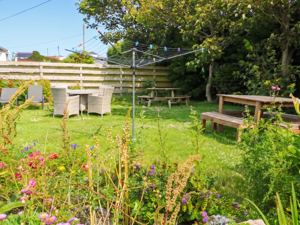 A garden with a table and chairs at Porth Ewyn in Trearddur Bay