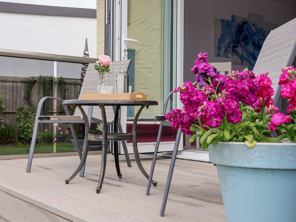 An outdoor seating arrangement with a table and chairs at Greenside Studio in Praa Sands