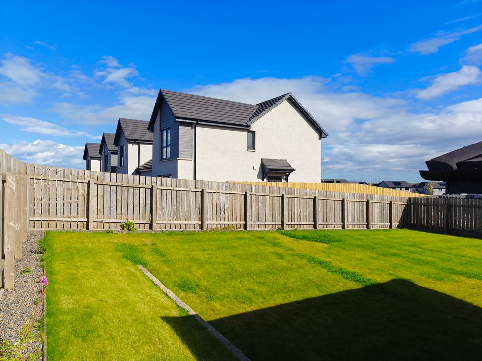 A garden with a lawn and houses in the background at 1 Westenra Gardens Cruden Bay