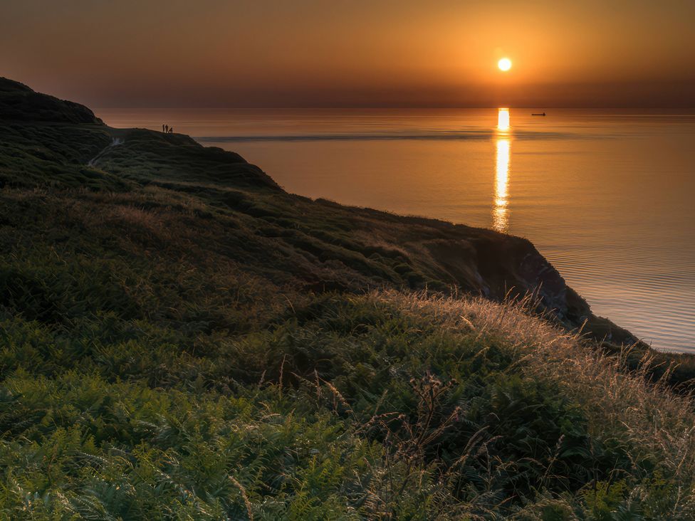 A landscape with a sunset over the ocean at 9 Manleigh Park in Combe Martin