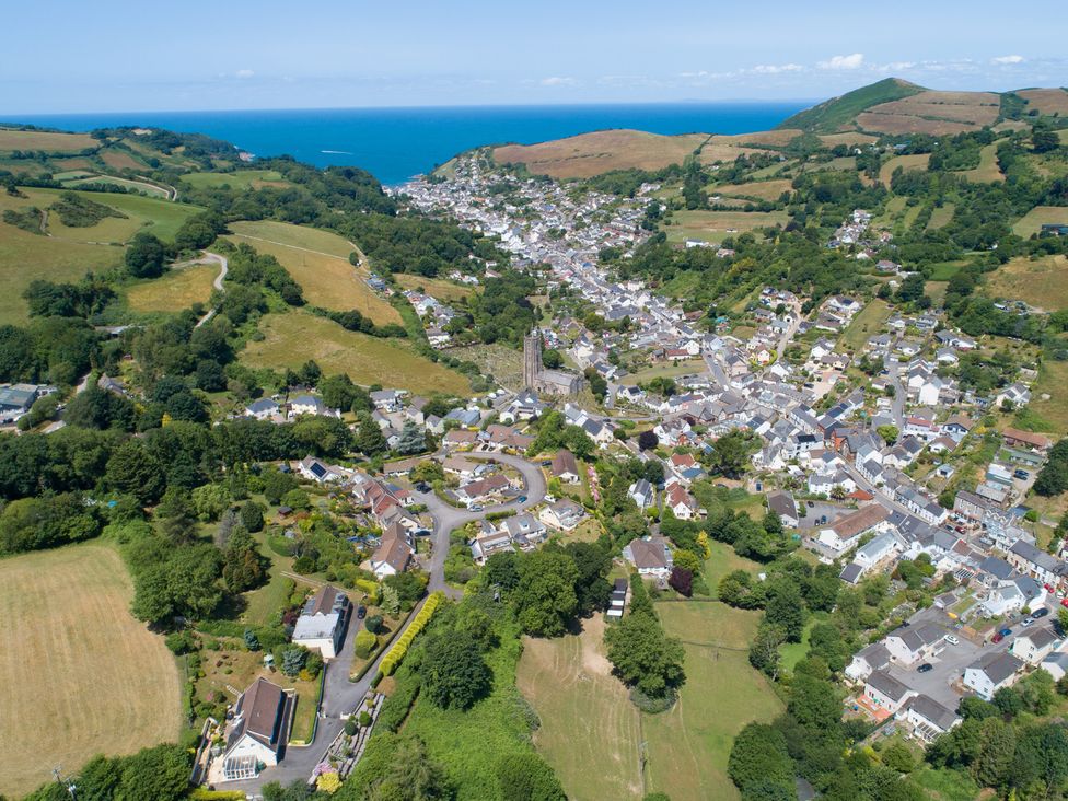 Aerial view of a coastal village with houses and fields at 15 Manleigh Park Combe Martin