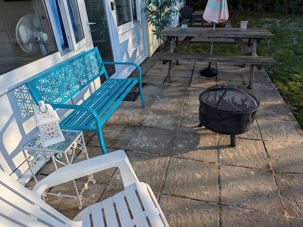 An outdoor patio with seating and a fire pit at 21 The Glade Kilkhampton