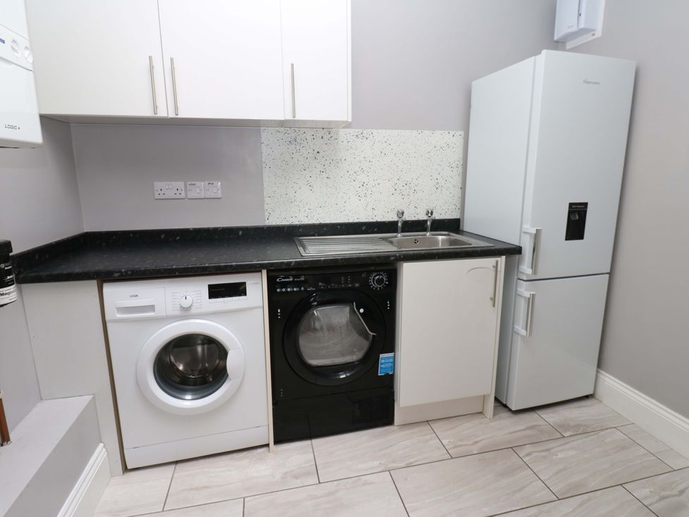 A kitchen with a washing machine and refrigerator at Fern Lee in Carlisle