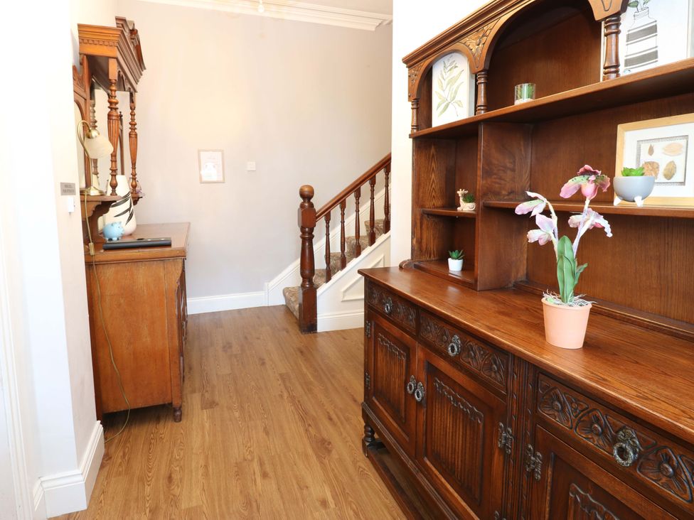 A hallway with a cabinet and staircase at Fern Lee in Carlisle