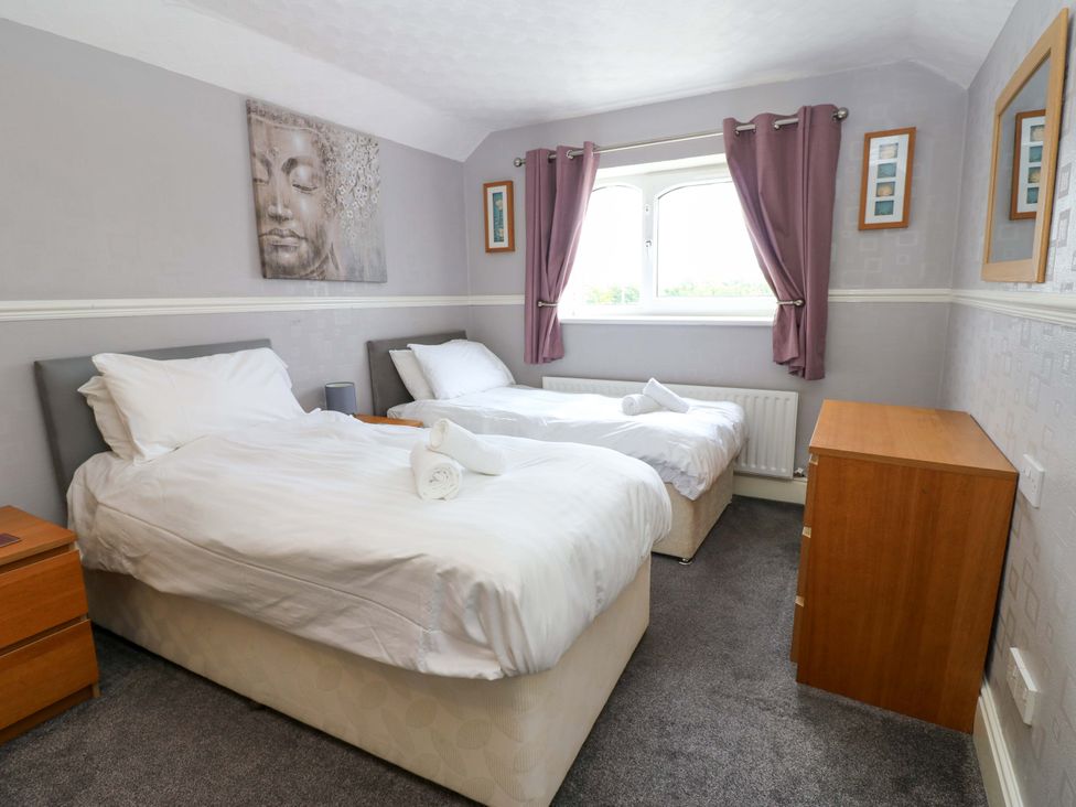 A bedroom with two single beds and a nightstand at Fern Lee in Carlisle