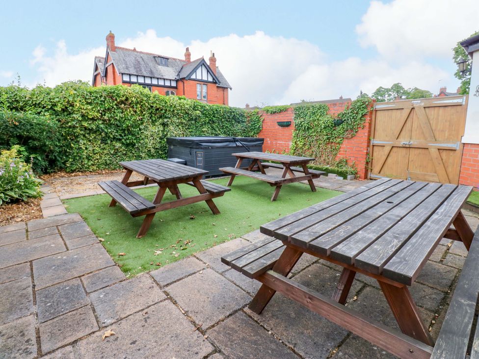 An outdoor area with picnic tables and a hot tub at Fern Lee in Carlisle
