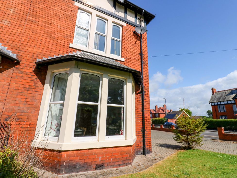 A corner of a red brick house with bay windows and a pathway at Fern Lee in Carlisle