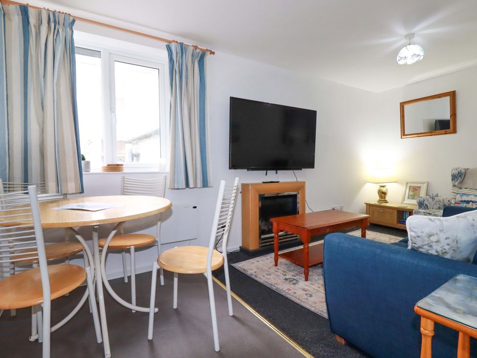 A living room with a dining table and chairs at Seaside Apartment in Looe