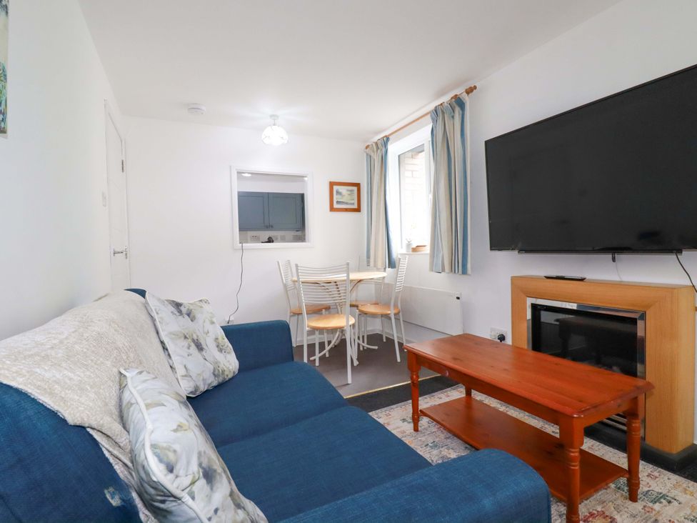 A living room with a sofa and dining table at Seaside Apartment in Looe