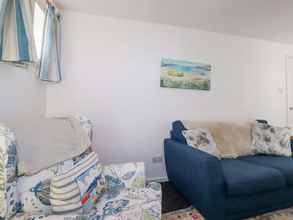 A living room with a sofa and armchair at Seaside Apartment in Looe