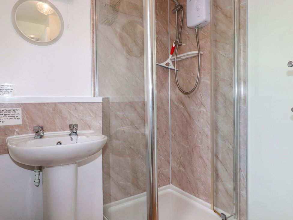 A bathroom with a shower and sink at Seaside Apartment in Looe