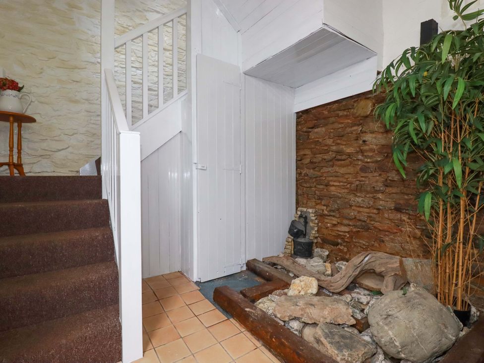 A hallway with stairs and rocks at Seaside Apartment in Looe