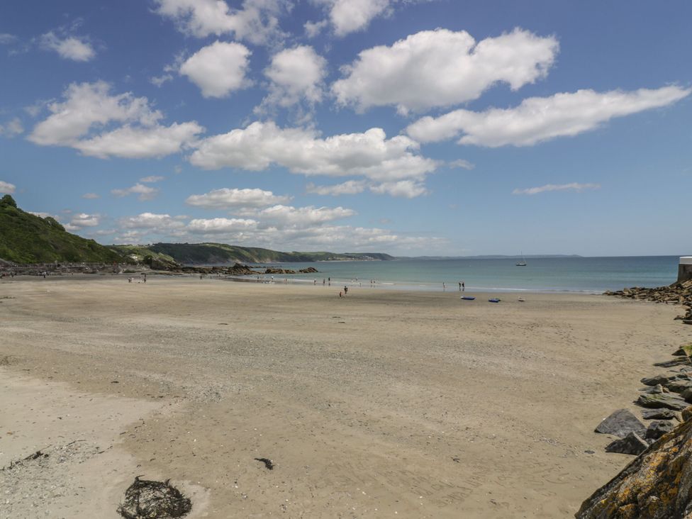 A beach with people walking and water at Seaside Apartment in Looe
