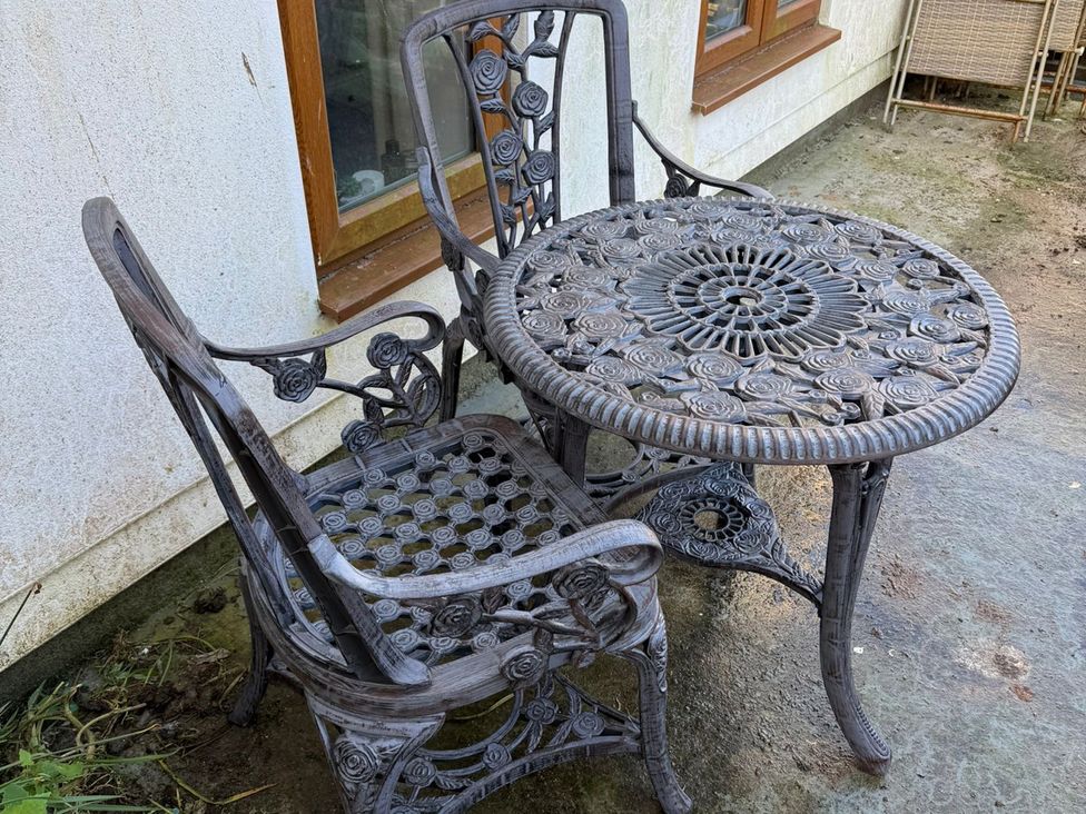 A decorative table and chair in a garden at Seaside Apartment in Looe