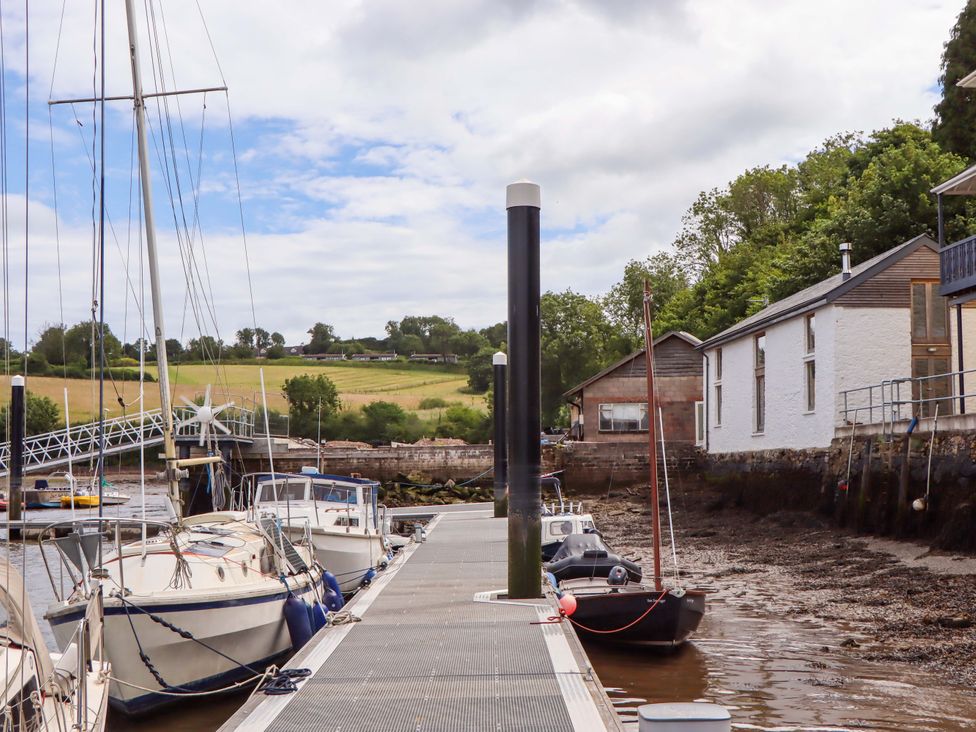 A dock with boats moored along the water at Dolphin Cottage in Brixham