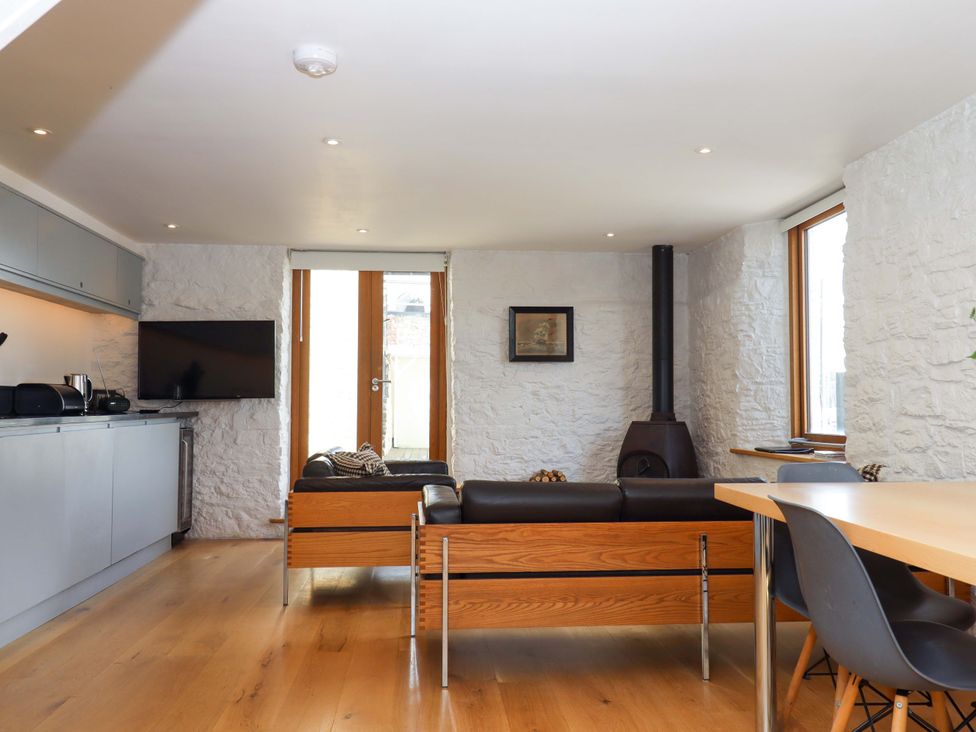 A living room with a sofa and table at Dolphin Cottage in Brixham
