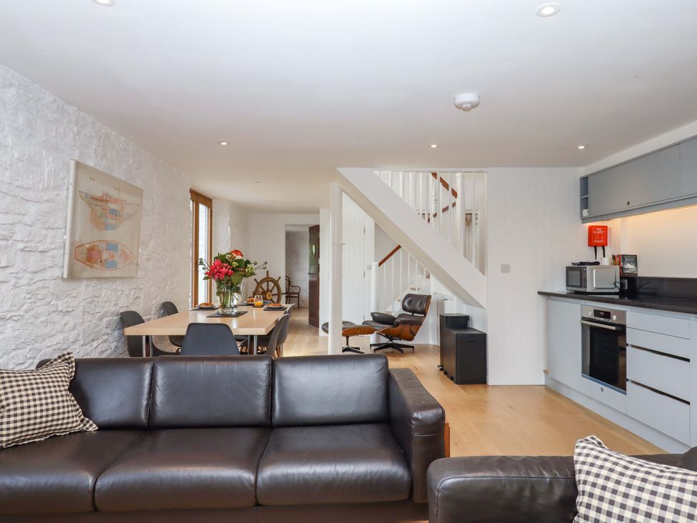 A living room with a sofa, table, and chairs at Dolphin Cottage in Brixham