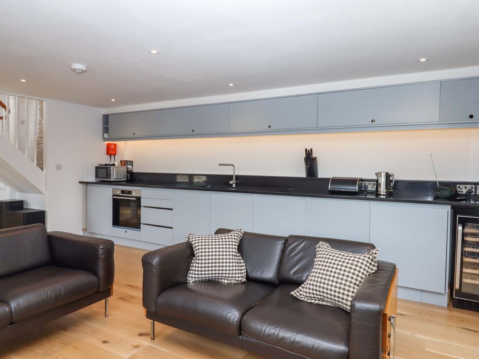 A kitchen with cabinets and appliances at Dolphin Cottage in Brixham