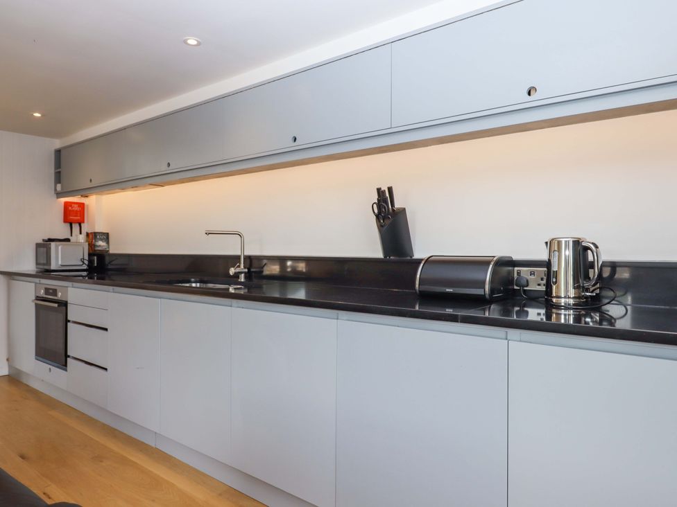 A kitchen with modern appliances and cabinetry at Dolphin Cottage in Brixham