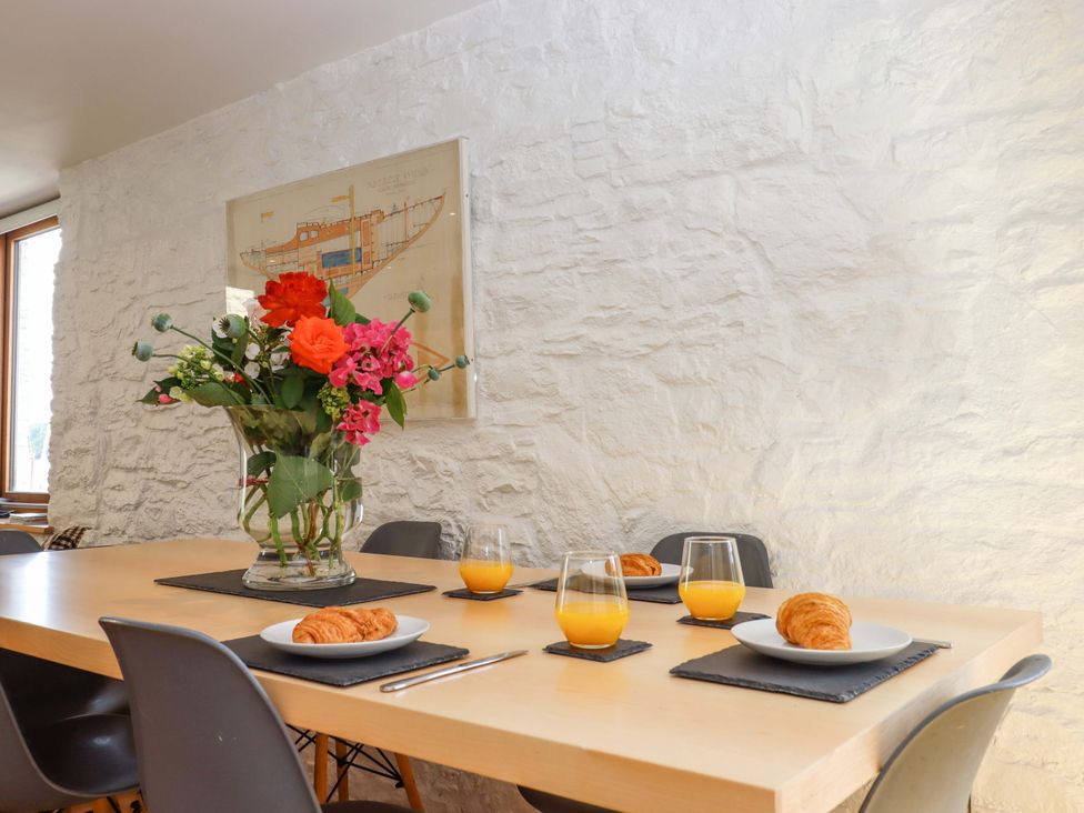 A dining room with a table set for breakfast at Dolphin Cottage in Brixham