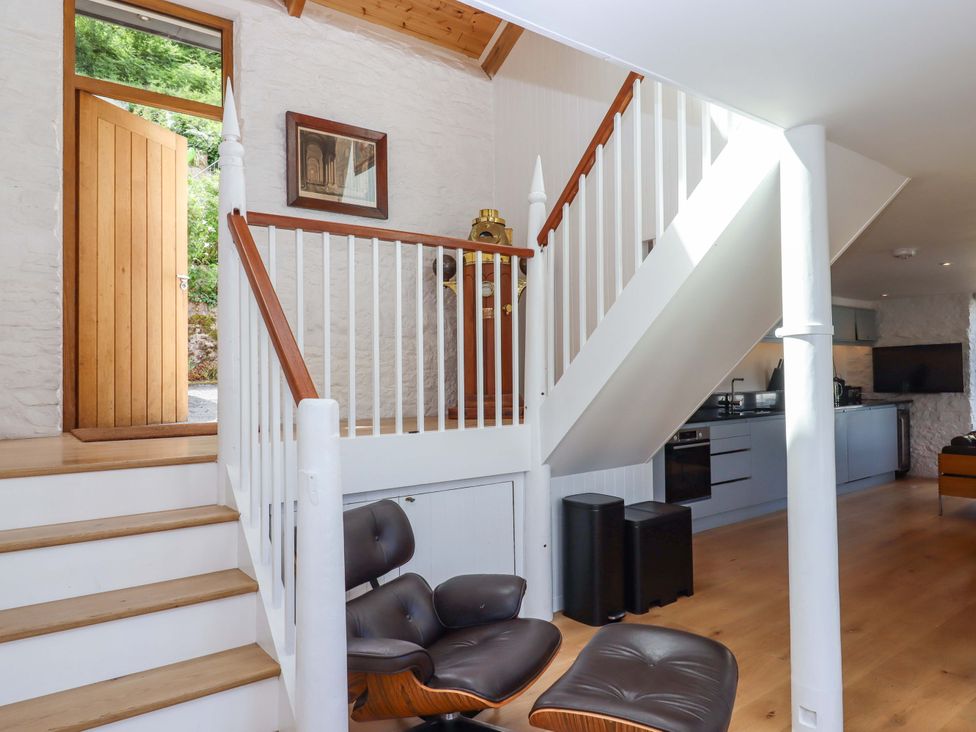 An entrance with stairs and armchair at Dolphin Cottage in Brixham