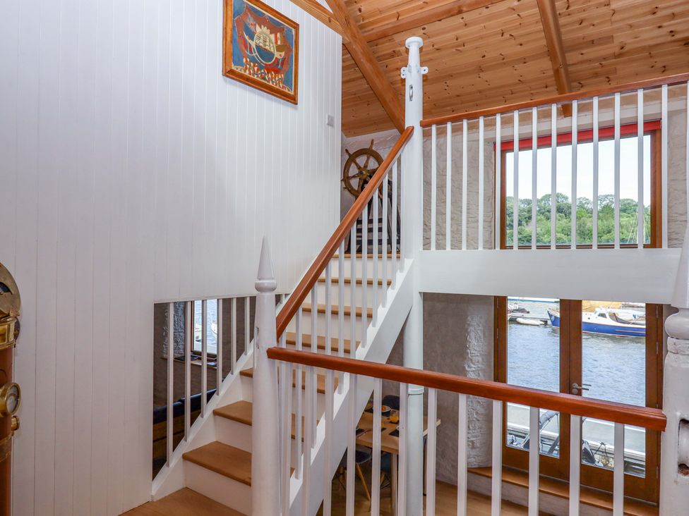 A staircase and wall with artwork in a hallway at Dolphin Cottage in Brixham