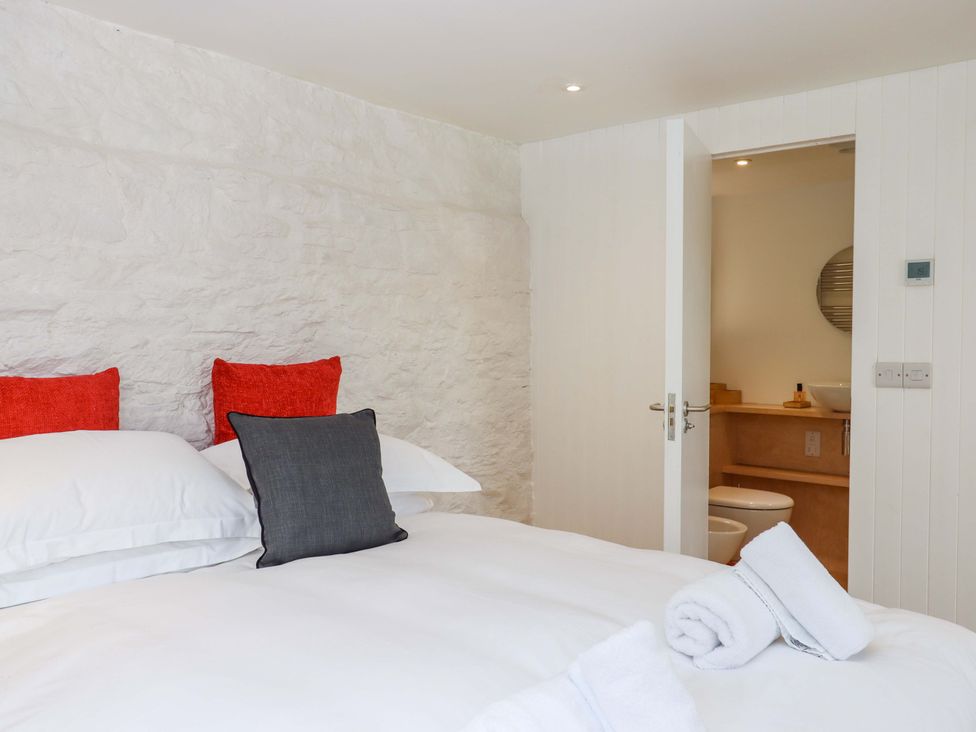 A bedroom with a double bed and adjoining bathroom at Dolphin Cottage in Brixham